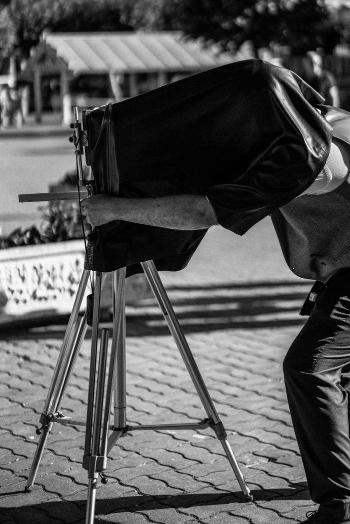 about-us-01 Photographie en noir et blanc d’un photographe vintage utilisant un appareil grand format en extérieur.